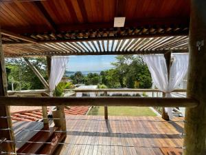 伊利亚贝拉Santomar Guest House的房屋的甲板上设有白色窗帘,享有风景。