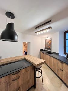 莱博德普罗旺斯La Maison de Pierrette的厨房配有木制柜台和木桌。