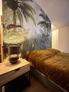 莱博德普罗旺斯La Maison de Pierrette的一间卧室设有床铺和棕榈树墙