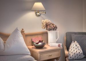 圣坎迪朵Il Tyrol的一间卧室配有一张床和一张花瓶桌子