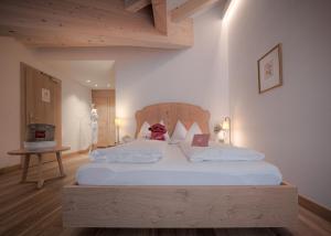圣坎迪朵Il Tyrol的卧室配有一张白色大床和木制床头板