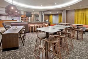 威奇托Springhill Suites by Marriott Wichita East At Plazzio的一间带桌椅的餐厅和一间酒吧