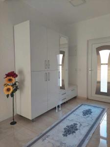 盖夫盖利亚Villa with mountain view的一间设有白色橱柜和花瓶的房间