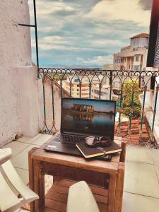 里约热内卢Rio World Connection Hostel的坐在阳台上的一张桌子上的笔记本电脑