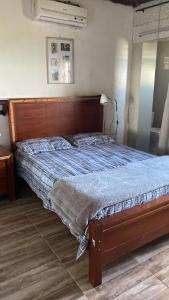 格拉瓦塔Rancho Mateus!的卧室内的一张带木制床头板的床