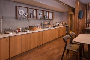 赫恩登赫恩登雷斯顿春季山丘套房酒店的厨房配有木制橱柜和桌椅