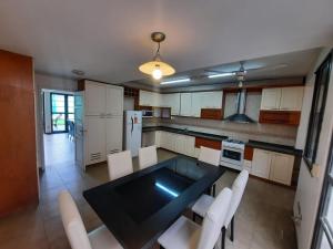 门多萨MODERNA x 11 Pax的厨房配有黑桌和白色椅子