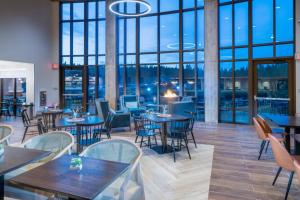 艾兰帕克SpringHill Suites Island Park Yellowstone的餐厅设有桌椅和大窗户。