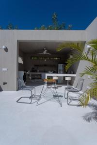 埃斯孔迪多港Casa SANA的大楼内带两把椅子和一张桌子的庭院