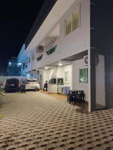 邦比尼亚斯Residencial Brisa do Mar 2的白色的建筑,有汽车停在停车场