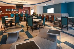 俄克拉何马城俄克拉荷马市机场万豪春季山丘套房酒店的一间带桌椅的餐厅和一间酒吧