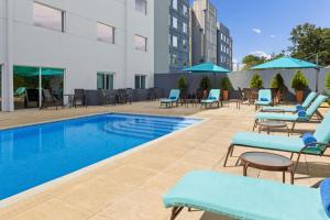 阿拉胡埃拉阿拉胡埃拉圣荷西机场万怡酒店的一个带躺椅的游泳池和一间酒店