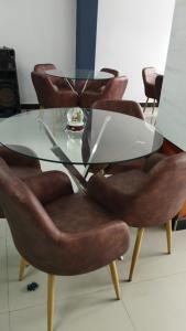 Bagua GrandeHOTEL VIP 46 SSQS的玻璃餐桌周围摆放着皮椅
