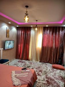 曼苏拉A 5-star hotel room in front of Mansoura University的一间卧室配有窗帘,卧室内配有一张床