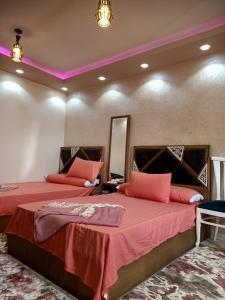 曼苏拉A 5-star hotel room in front of Mansoura University的一间卧室配有两张红色床单