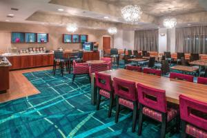 桑福德SpringHill Suites by Marriott Orlando North-Sanford的一间带桌椅的餐厅和一间酒吧