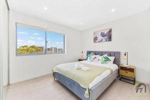 悉尼Entire Home in Lidcombe的白色的卧室设有床和窗户