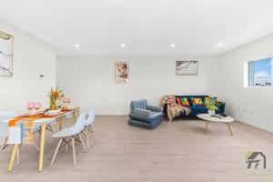 悉尼Entire Home in Lidcombe的客厅配有蓝色的沙发和桌子