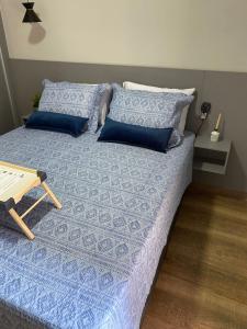 圣维森特岛Apartamento Flat Palladium的一张带蓝色床单和蓝色枕头的床