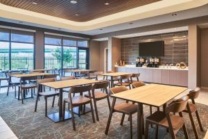 奥兰多SpringHill Suites by Marriott Orlando Lake Nona的一间带桌椅的餐厅和一间酒吧
