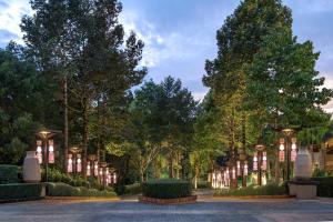 清莱Le Meridien Chiang Rai Resort, Thailand的公园里树木和灯光的小路