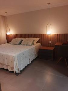 萨尔瓦多Casa em Praia do Flamengo /Salvador-Ba的一间卧室配有带2个枕头和2盏灯的床