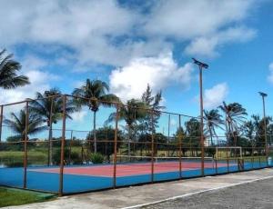 萨尔瓦多Casa em Praia do Flamengo /Salvador-Ba的棕榈树围栏后面的网球场