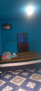 圣佩德罗拉拉古纳Hotel y Restaurante Playa Linda的一间卧室设有一张床和蓝色的墙壁