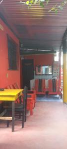 圣佩德罗拉拉古纳Hotel y Restaurante Playa Linda的一间设有黄色桌子和红色椅子的用餐室