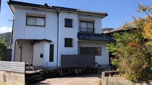 雾岛市おもや彩OmoyaSai-天然温泉付き貸別荘1棟貸し的前面有长凳的白色房子