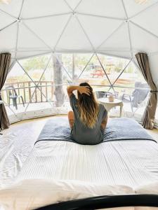 BalilihanEco Glamping Treehouses Closest Resort To All Tourist Attractions的坐在帐篷里的床上的女人
