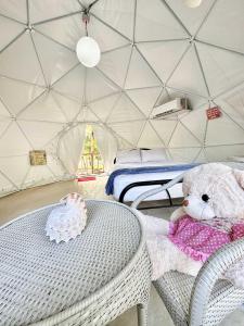BalilihanEco Glamping Treehouses Closest Resort To All Tourist Attractions的圆顶帐篷桌子上的泰迪熊