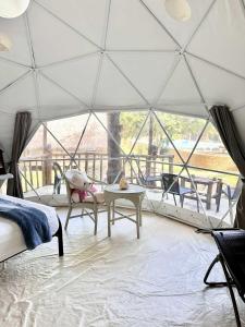 BalilihanEco Glamping Treehouses Closest Resort To All Tourist Attractions的带帐篷、床和桌子的客房