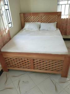 Boma la Ngombe4 BR/5 Bathroom Bungalow的一张位于带木床架的客房的床位