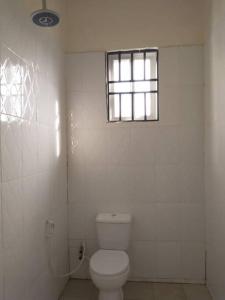 Boma la Ngombe4 BR/5 Bathroom Bungalow的白色的浴室设有卫生间和窗户。