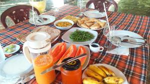 坦加拉White Villa Goyambokka的一张桌子,上面放着食物和水果盘