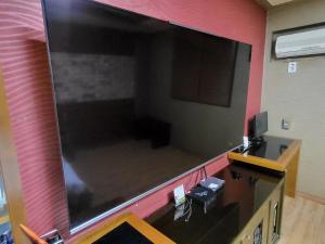 利川市Mokhwa Motel的挂在墙上的大屏幕平面电视