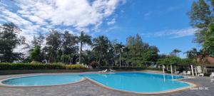 Ban ChamrungVIP Condochain Rayong的树木繁茂的公园里的一个大型游泳池