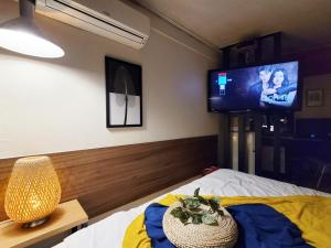 议政府市Residence YeoYu Uijeongbu Station的卧室配有一张床铺,墙上配有电视