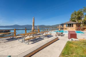 国王海滩Luxurious Lakefront Condo with Lake Views in Brockway Springs Resort Close to Slopes的一组长椅和桌子,位于游泳池旁