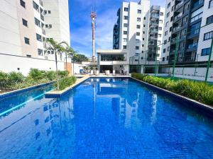 伊列乌斯Apartamento Para Temporada的大楼中间的大型蓝色游泳池
