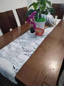 实兆远Lekir baiduri homestay的一张桌子,桌子上摆放着桌布,木桌上摆放着鲜花