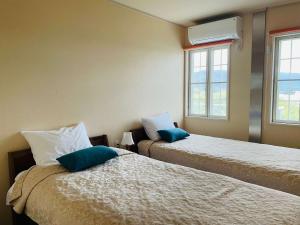 FuchisakiLa Classe Angel Road 2 - Vacation STAY 71497v的客房配有两张带蓝色枕头的床。