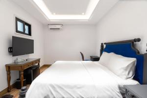 岘港Quang Minh Riverside Hotel Danang的卧室配有白色的床和电视。