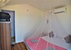 阿贡达Agonda Sun Set的一间卧室配有一张带蚊帐的床