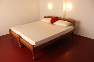 阿勒皮Marari Sunset Beach Villa的一张床上有两个红色枕头的房间