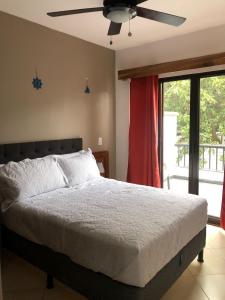 塔马林多Full condo in Tamarindo, CR的一间卧室配有一张床和吊扇
