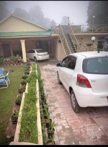 穆里Rashk e Qamar的停在房子前面的白色汽车