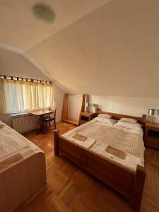 VILLA M Slatina Banja Luka的一间大卧室,配有两张床和一张书桌