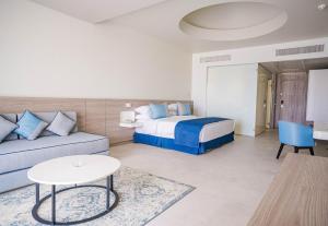 马萨阿拉姆SENTIDO Reef Oasis Suakin Resort的一间卧室配有一张床、一张沙发和一张桌子